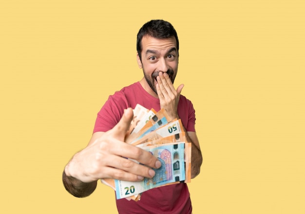 Man taking a lot of money pointing with finger at someone and laughing 