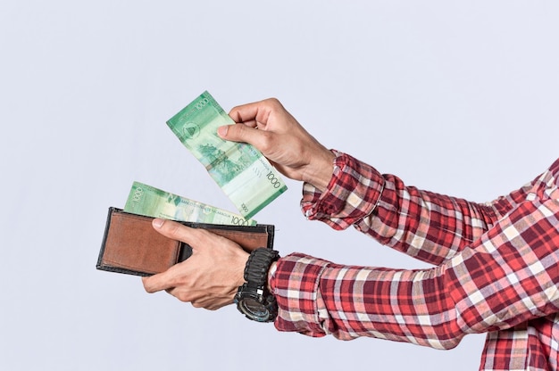 Man taking money out of his wallet close up of hands taking money out of his wallet isolated Nicaraguan banknotes cash payment concept