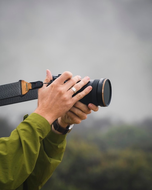 Человек фотографирует в туманном лесу
