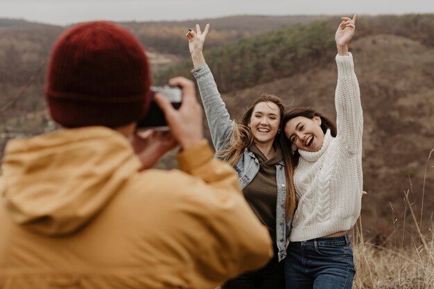 写真 自然の中で女性の写真を撮る男