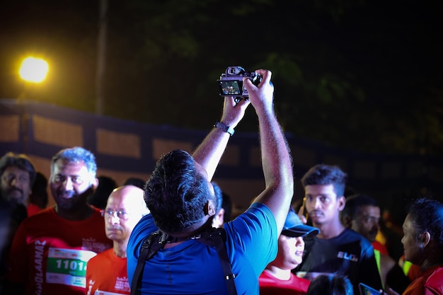 A man taking a picture of a crowd at a marathon