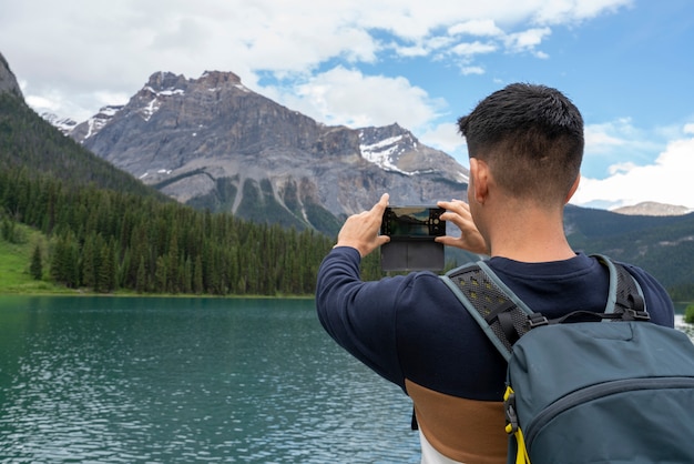 A man taking a picture to the mountains