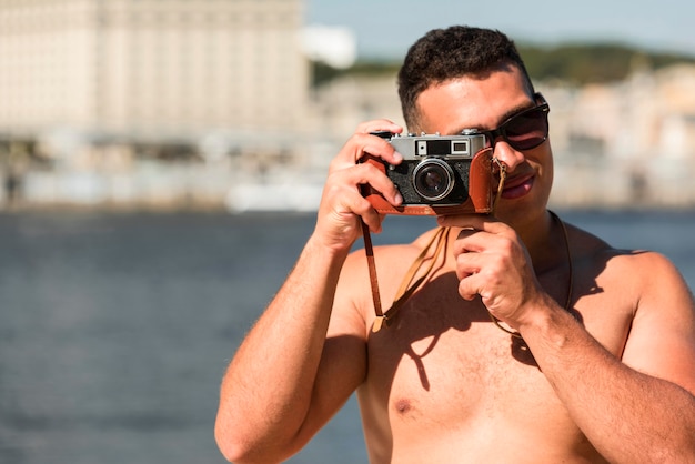 사진 해변에서 카메라로 사진을 찍는 남자