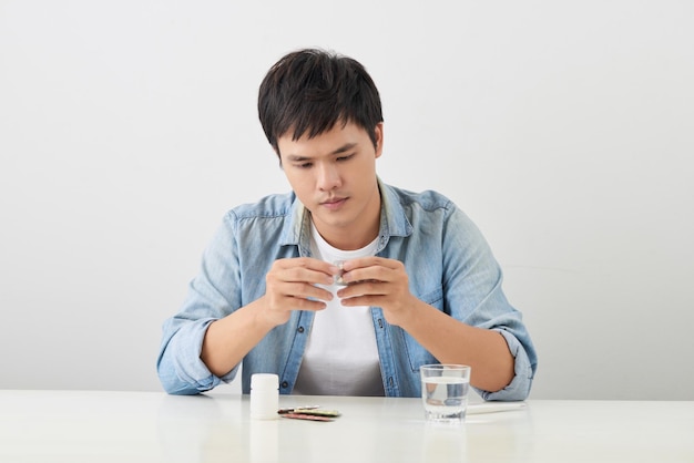 Man taking pill out from blister pack at home