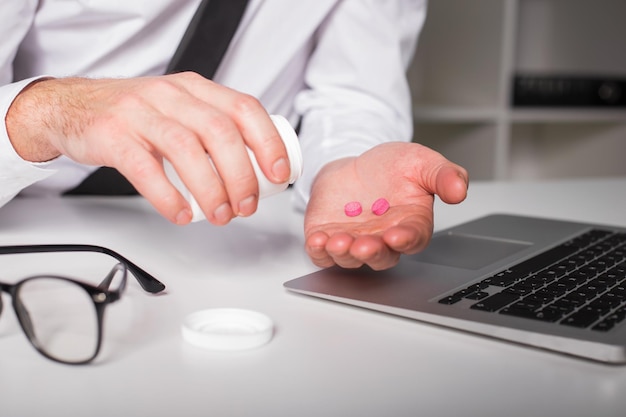 Man taking pills at the office