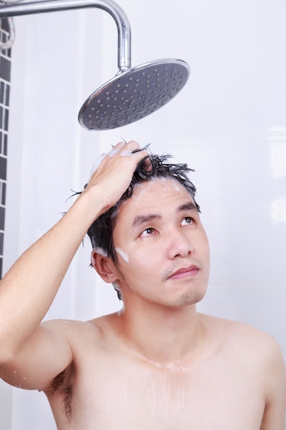 man taking a rain shower and washing hair in bathroom