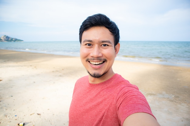 Man taking selfie on the beach.