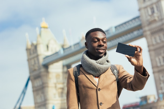 タワーブリッジとロンドンでselfieを取っている人