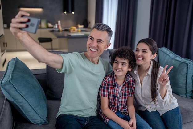 Man taking selfie with joyful woman and boy