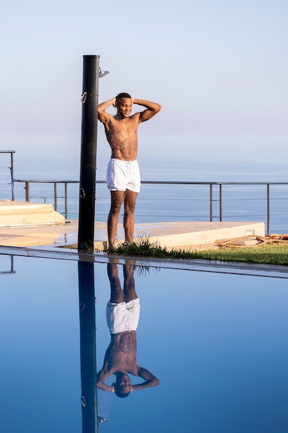 Photo man taking shower outside full shot