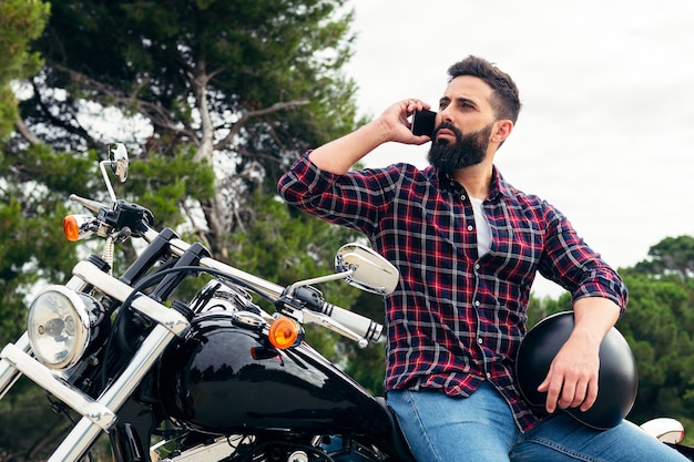 バイクに座って携帯電話で話している男