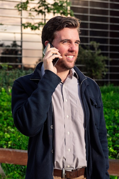 Man talking by phone next to an office building