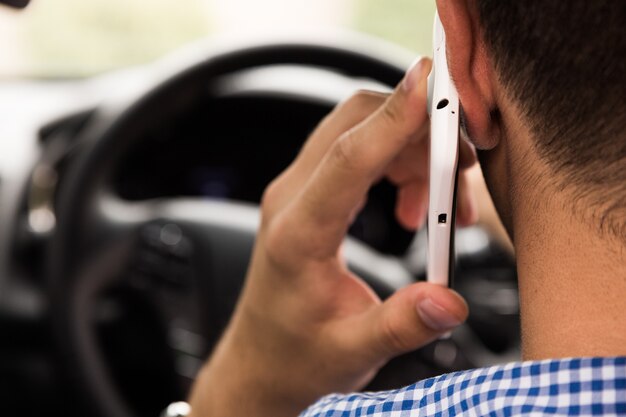 Man talking over mobile phone while driving car