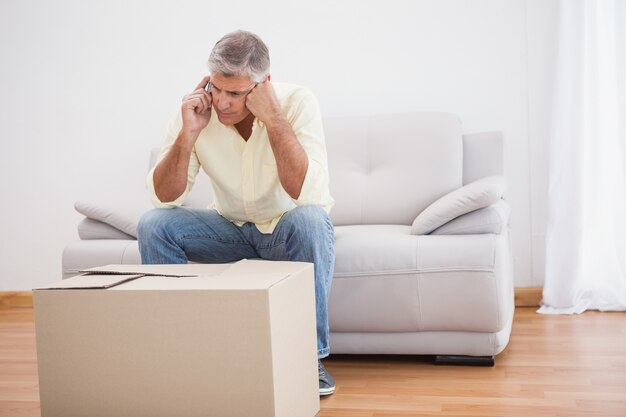 Man talking on phone looking at box