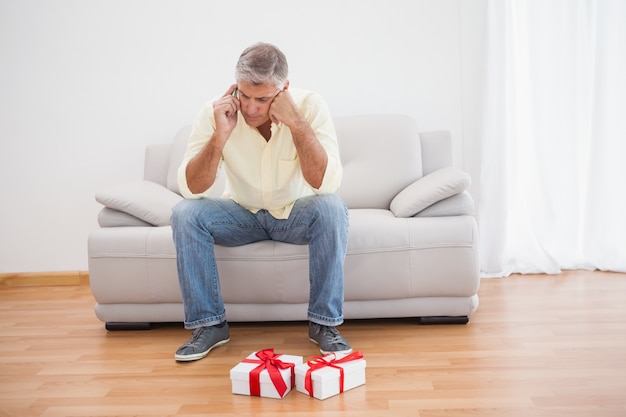 Man talking on phone looking at gifts