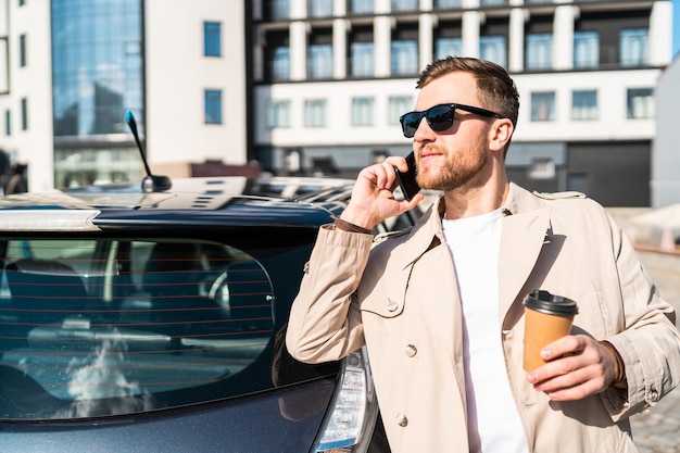 彼の車の近くで電話で話している男