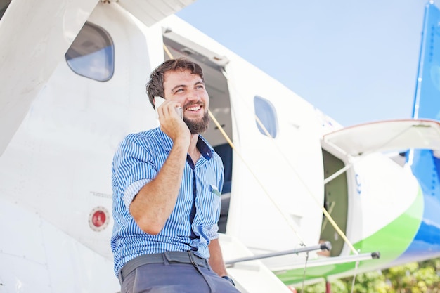 Foto uomo che parla al telefono fuori dal jet privato