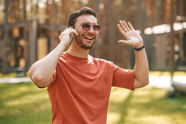 Man talking on smartphone affably gesturing