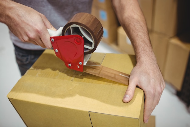 Man taping box in warehouse