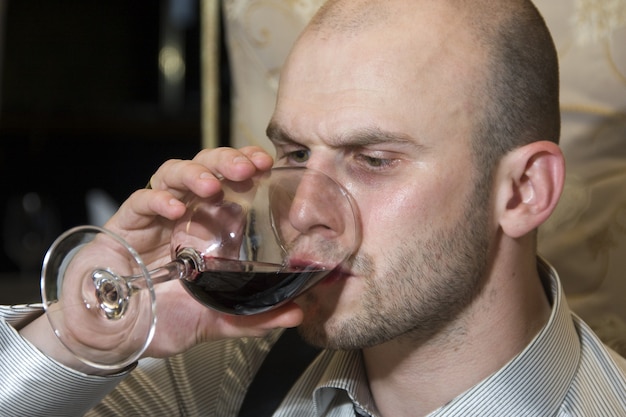 Foto uomo che assaggia il vino rosso