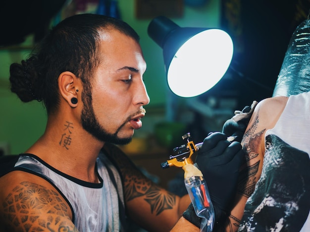 Photo man tattooing on hand