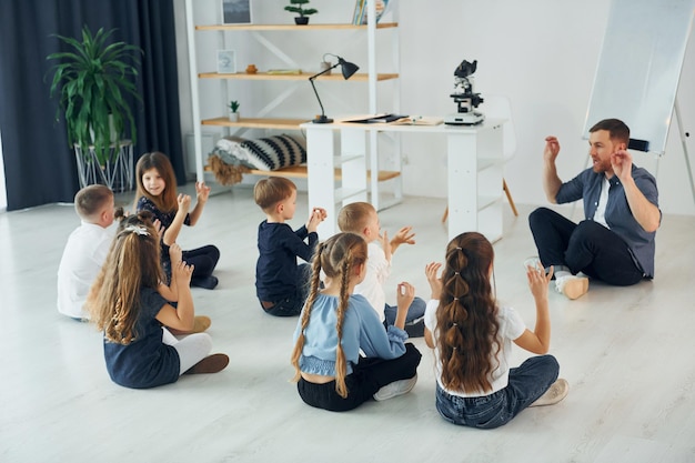 Man teaches gesture language Group of children students in class at school with teacher