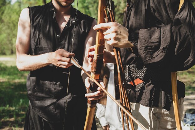 A man teaches to shoot with a bow The boy holds a bow in his hands