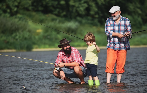 Man teaching kids how to fish in river father son and grandfather fishing generations men three gene