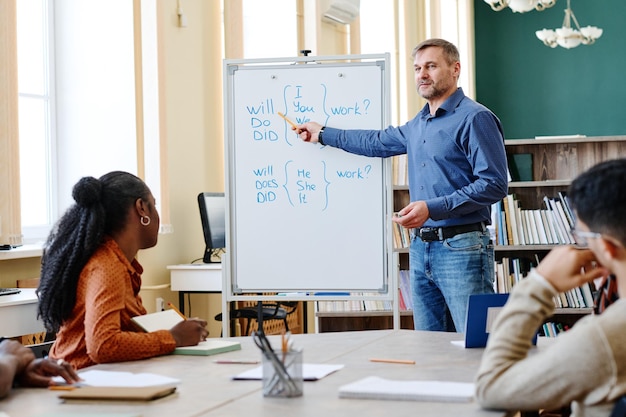 Photo man teaching migrants english