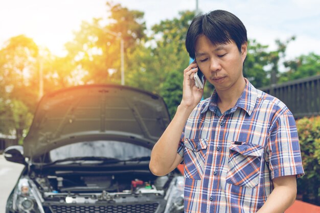 Man telefoneren voor hulp bij een kapotte auto