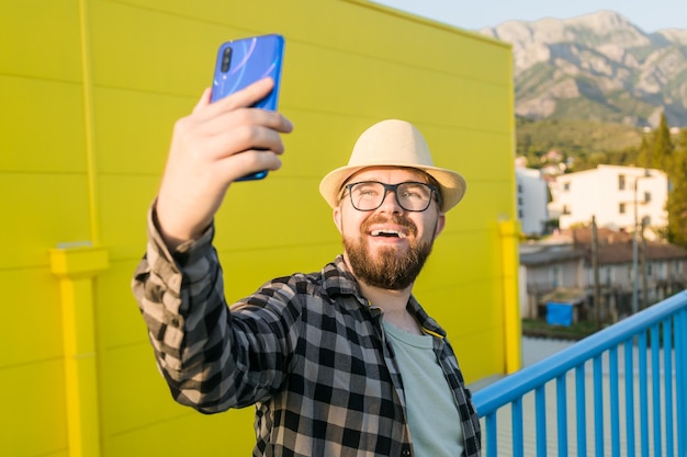 Uomo che dice qualcosa alla fotocamera mentre viaggia nel blog di sfondo del supermercato giallo della nuova città