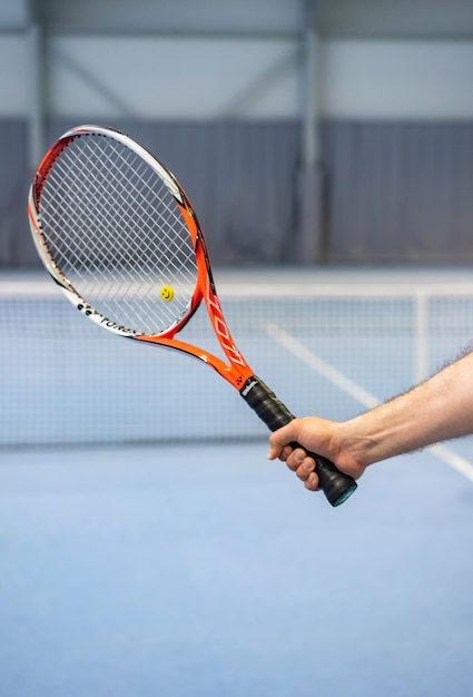 Man tennisracket van de handholding op tennisbaan