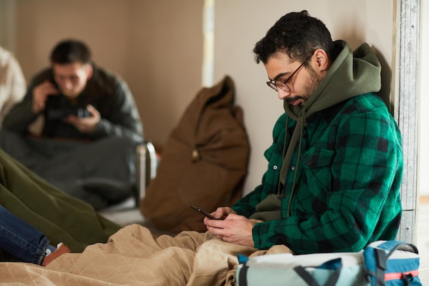 Foto uomo che manda un sms alla famiglia in rifugio