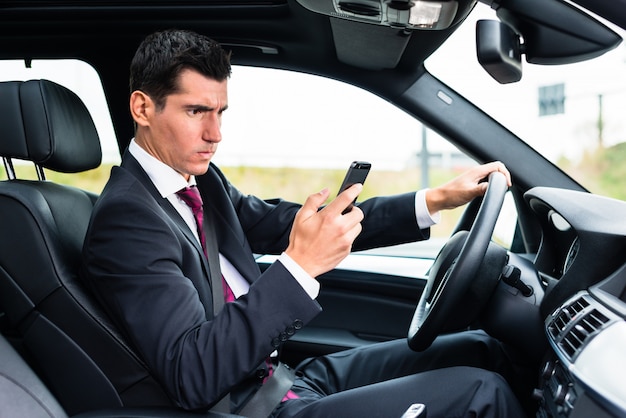 Man texting tijdens het rijden met de auto