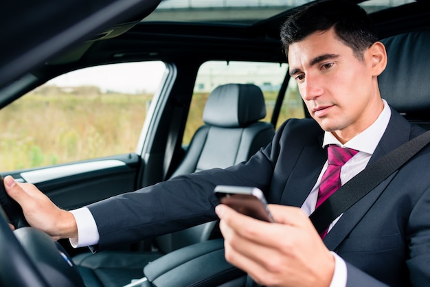 Man texting tijdens het rijden met de auto