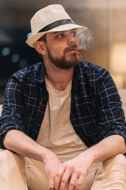 Man thinking about what to do while blowing smoke inside his house lifestyle concept