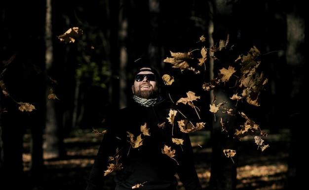 Uomo che lancia foglie d'autunno