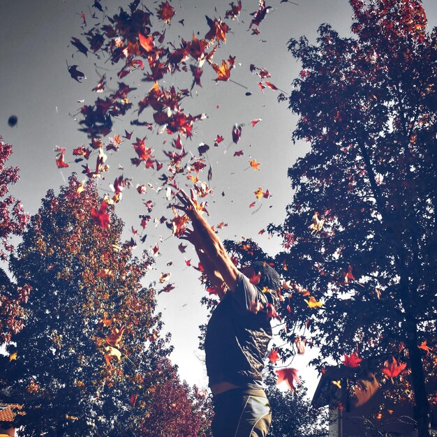 Photo man throwing leaves