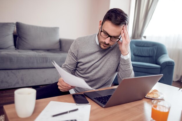 Man thuis aan het werk op een laptop