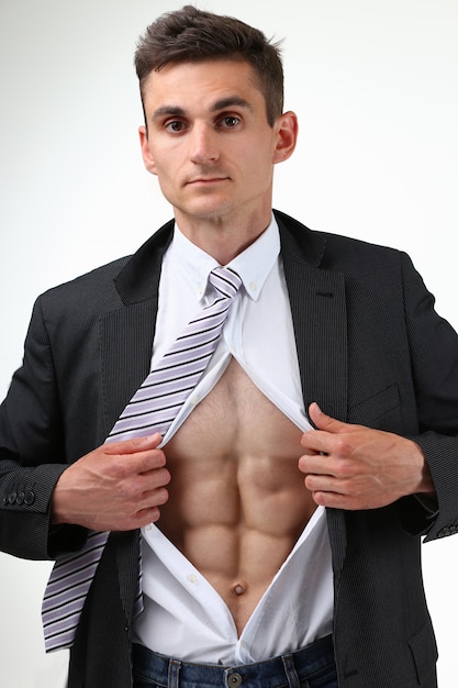 L'uomo in strappo della cravatta copre il torso mostrando gli addominali