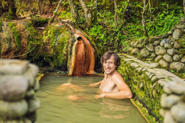 Foto man toerist in belulang hot springs in bali, village mengesta, penebel district, tabanan regentschap.