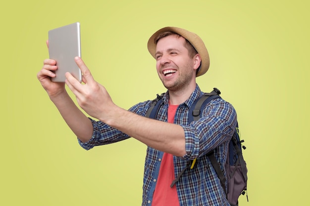 Man toerist in zomer hoed met behulp van digitale tablet