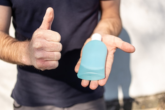 Man toont als en met een fles antibacteriële ontsmettingsmiddel