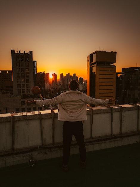 Uomo in cima all'edificio al tramonto