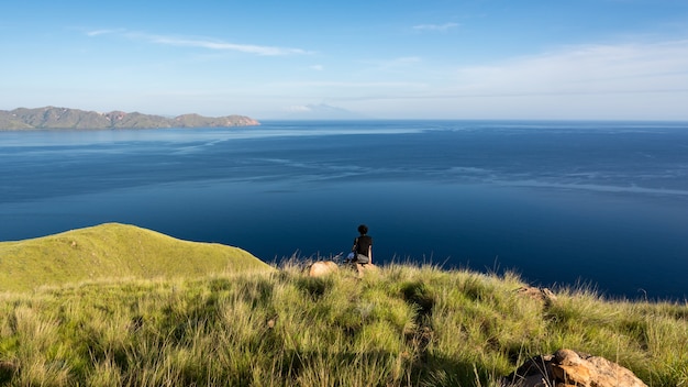 Foto un uomo in cima a gili lawa darat island in serata. parco nazionale di komodo, indonesia