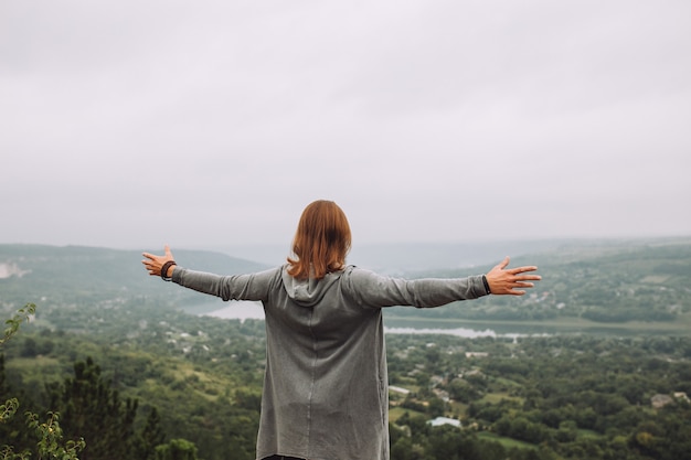 Man on the top of the mountain with hands up.