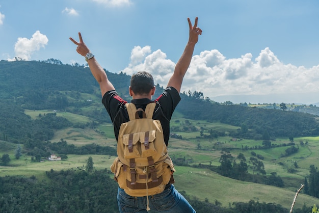 Man on top of a mountain with his hands up
