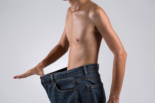 Man topless in big over-sized of jeans for diet 