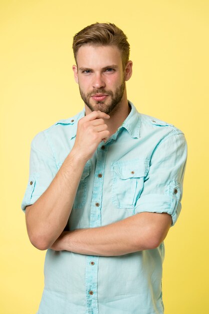 Man touch beard hair on unshaven face, barber concept. Barber shop for modern man. To shave or not to shave.