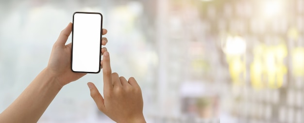 a man touching on blank screen smartphone in blurred glass wall office